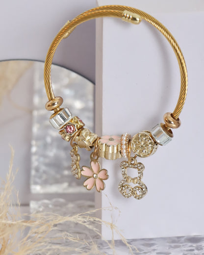 Pulseira dourada com pendentes rosa e dourados