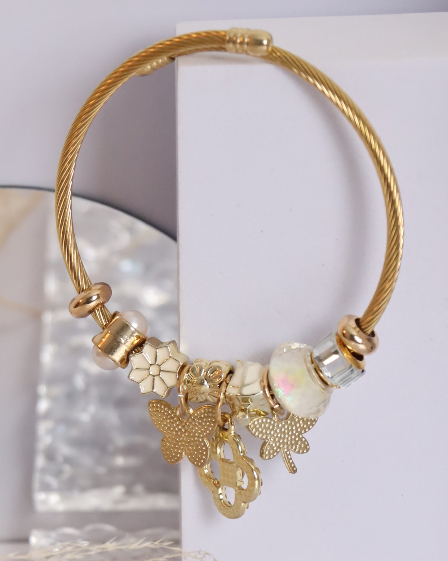 Pulseira dourada com pendentes em branco e dourado