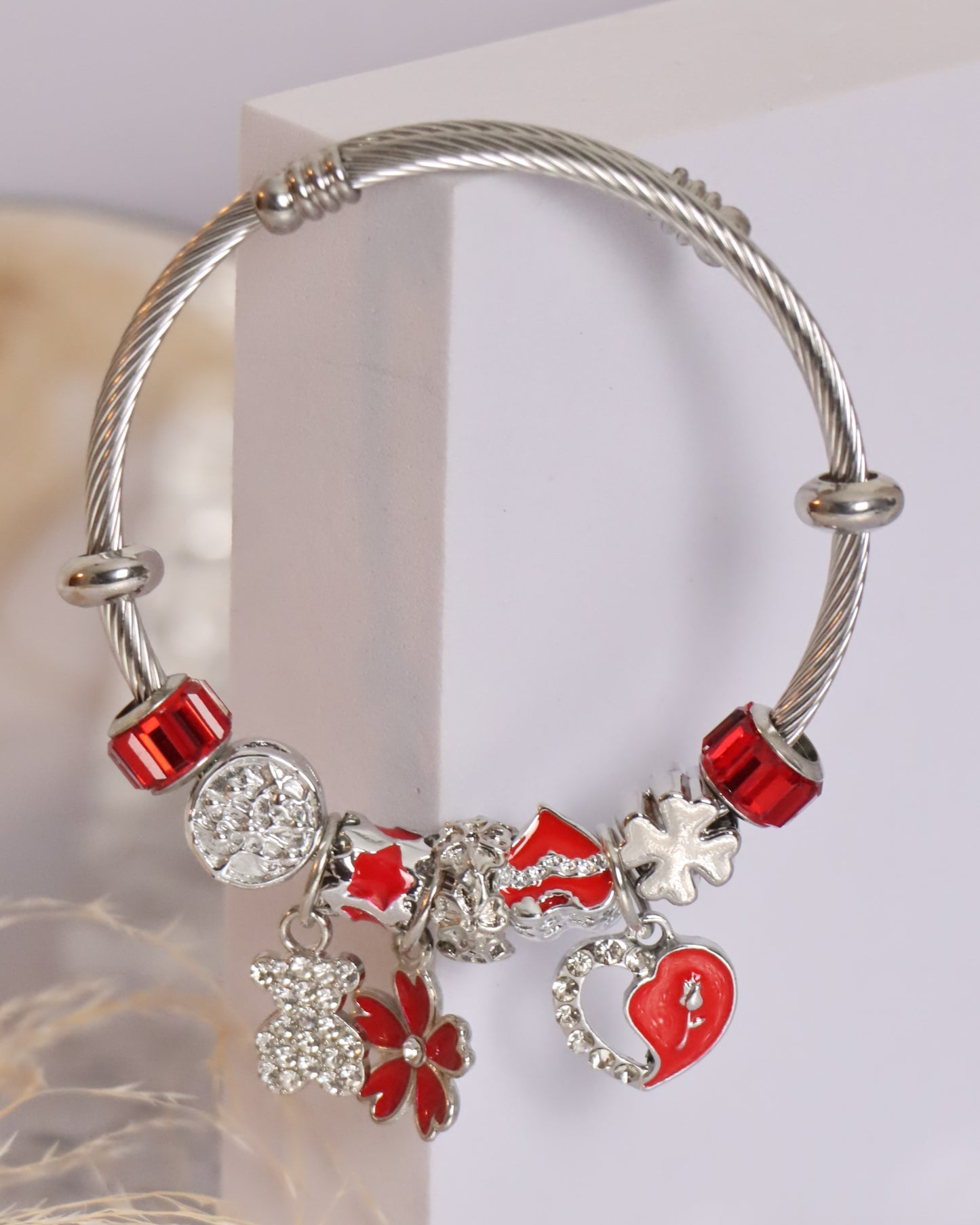 Pulseira prateada com pendentes em vermelho e prateado